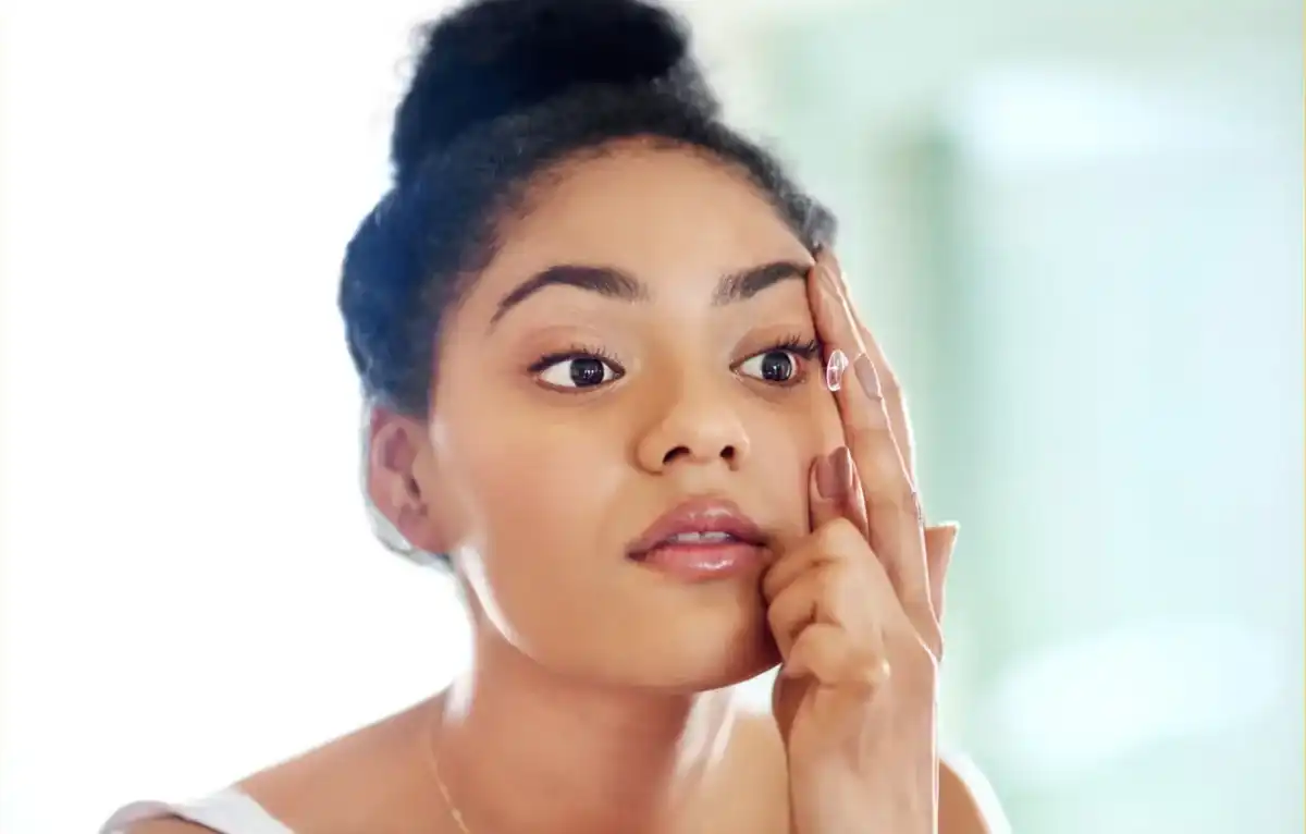 Patient placing a contact lens during a fitting in Syracuse, Utah
