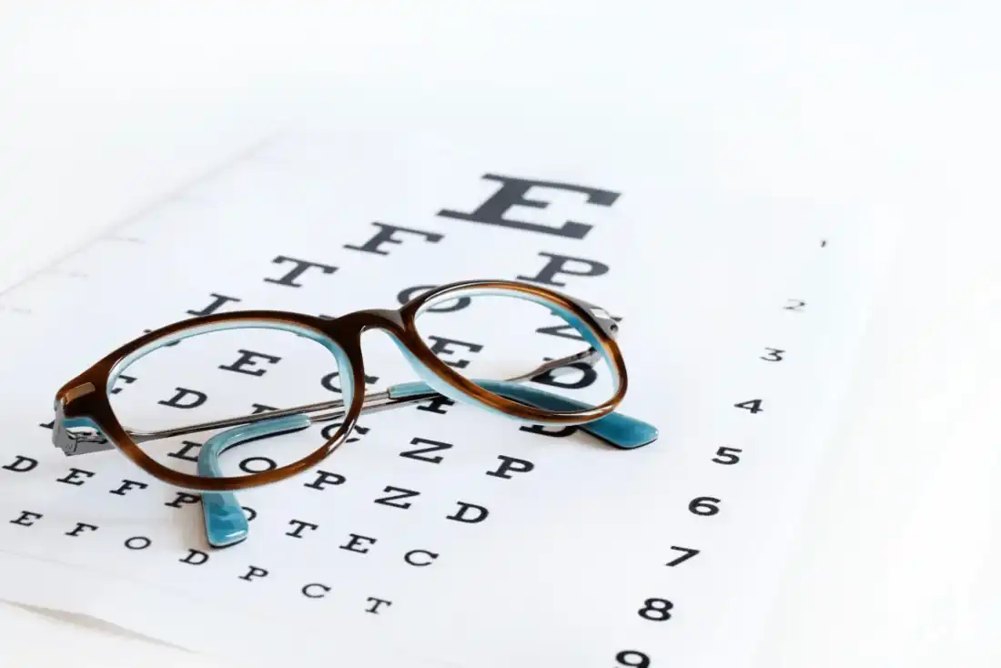 Glasses resting on an eye chart for an eye exam in Syracuse, Utah